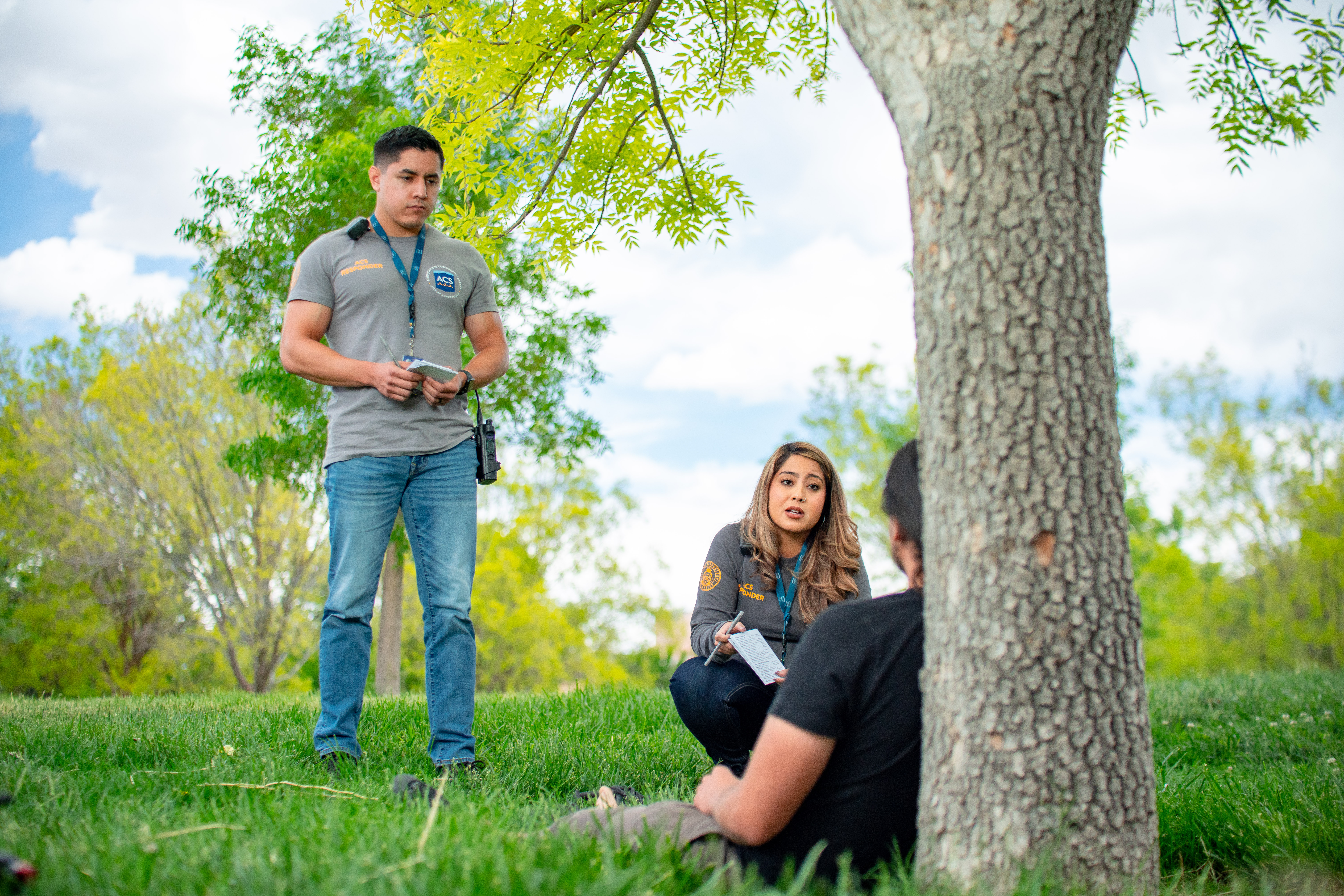 Two ACS Responders talking to a man in a park