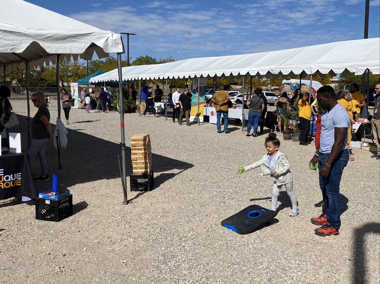 Child playing cornhole at fair