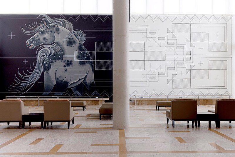Black and white mural in Museum lobby of horse and Indigenous geometric designs