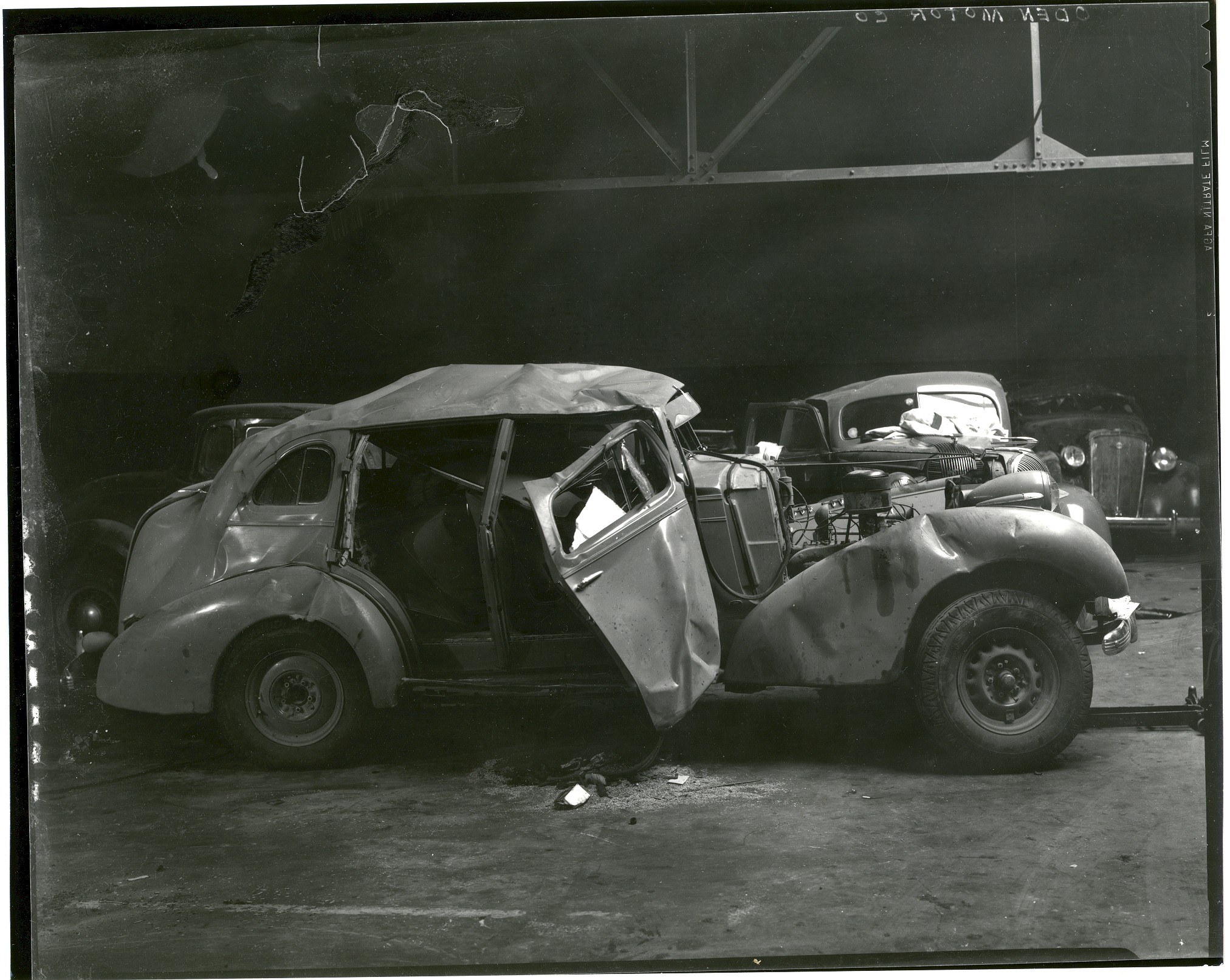 A black and white photograph of wrecked cars at Oden Motors