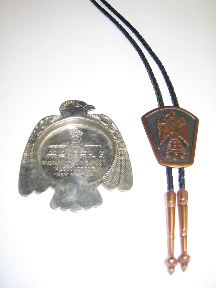 Native American artworks including a metal ash tray in the shape of a bird and a bolo tie.