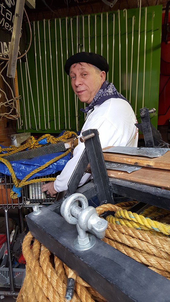 A person seated in a workshop looks back over their shoulder at the audience.