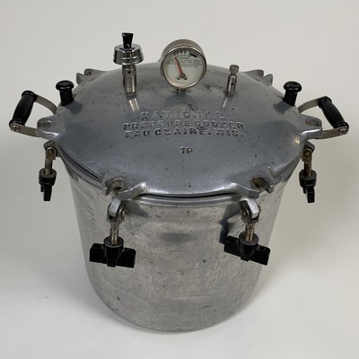 Recent History Acquisitions, April 2021. National Pressure Cooker Company, Pressure Cooker, heavy aluminum cast with brass rods and bakelite handles and thumbnuts, Albuquerque Museum, gift of Kate Padilla