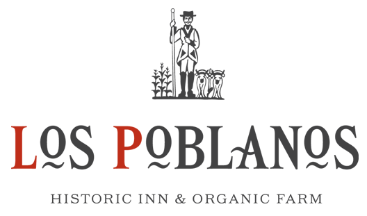 Los Poblanos logo The Los Poblanos in dark gray and red.