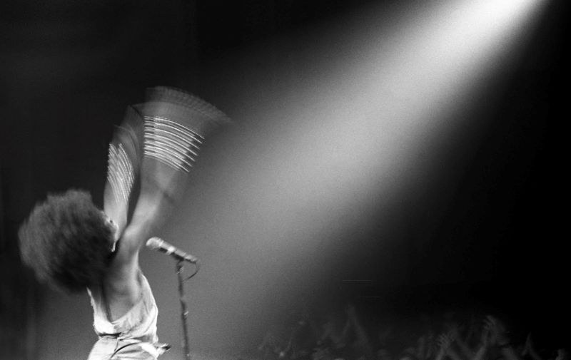 Photo of Erykah Badu singing before an audience