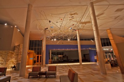 Karl Hofmann, Head Space (installation view) A sculpture composed of thin strips of wood, brightly painted panels, and LEDs hung from the ceiling of the Albuquqerque Museum lobby by fishing wire.