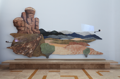 A detail of the left panel of Haunted, by artist Nicola López, an installation mounted on the wall of the Albuquerque Museum lobby. This panel depicts one half of a desert landscape. Multiple small projectors are mounted to the front of the panel, projecting videos onto the landscape.