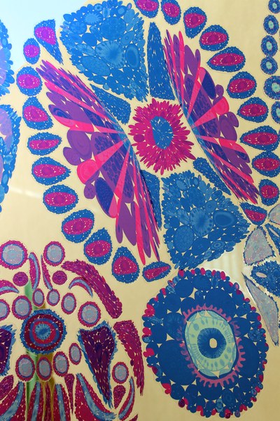 Detail of Meridiae by Lea Anderson, composed of translucent, colorful, circular shapes, installed on a window in the lobby of the Albuquerque Museum. 