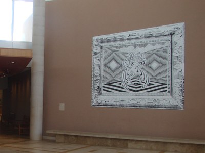 A detail image of the left half of a two-panel, black-and-white mural installed on the wall of the Albuquerque Museum lobby. The panel depicts the interior of a surreal room, surrounded by a faux frame.