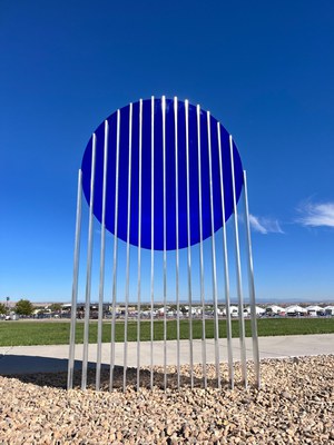 A sculpture for The Art of Annularity exhibition at the Balloon Museum. The sculpture is a large, flat, blue circle suspended in the air by a series of thin metal poles.