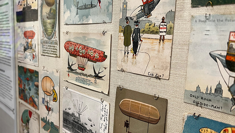 A close up of a wall collage of many color illustrations from the mid 19th century of modes of flight, both realistic and fanciful.
