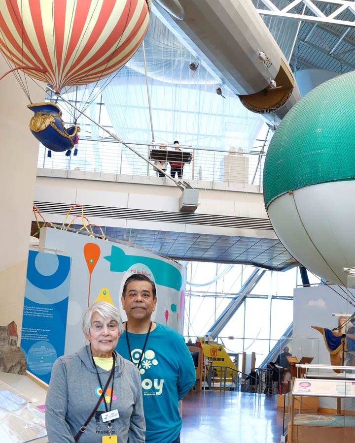 Docents Carol and Steve greeting visitors within the front entry of the Balloon Museum.