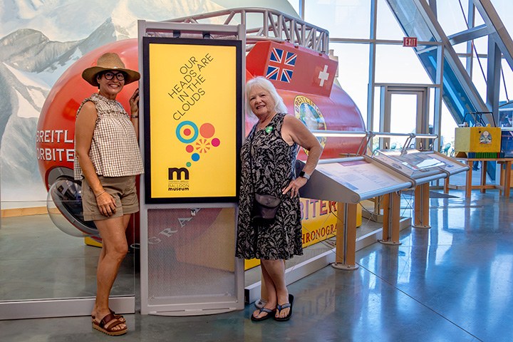 Two women standing in front of the replica of the Breitling Orbiter 3