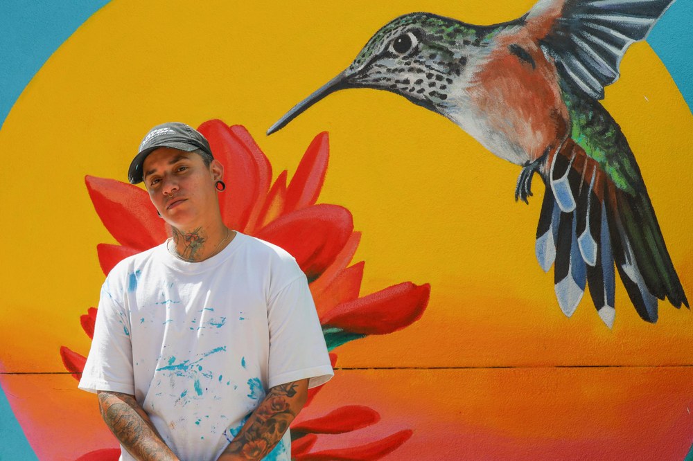 Jade Cruz pictured besides their artwork.