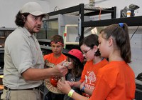 caption:A group of Camp BioPark students meet with a reptile keeper.