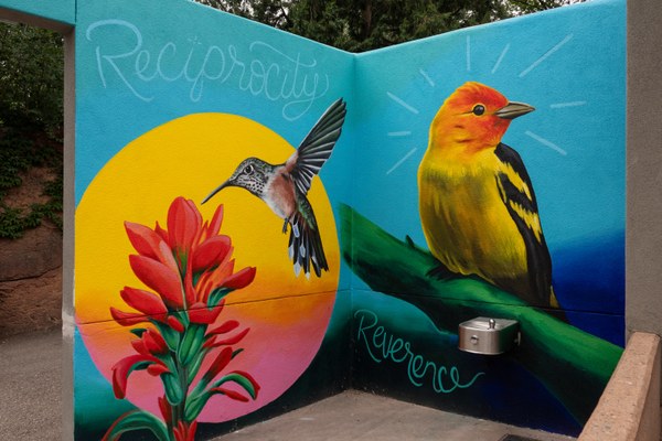 A portion of Cruz' mural features a broadtail hummingbird and western tanger along with words to encourage reflection.