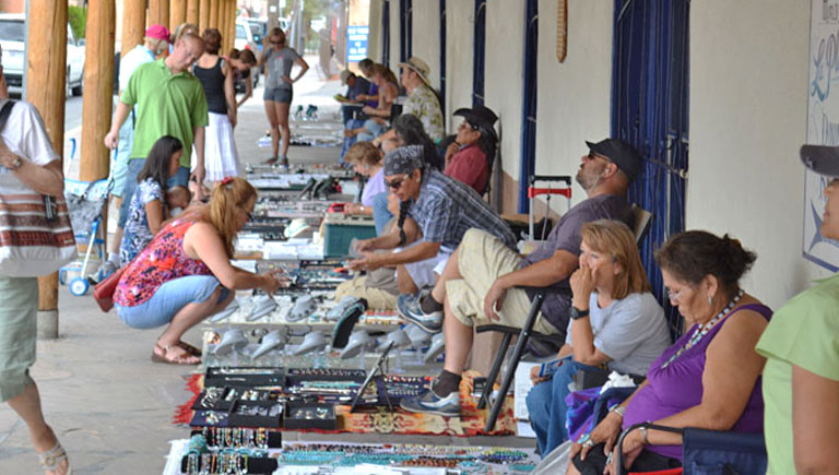 People shopping from artisans at the Old Town Portal Market.