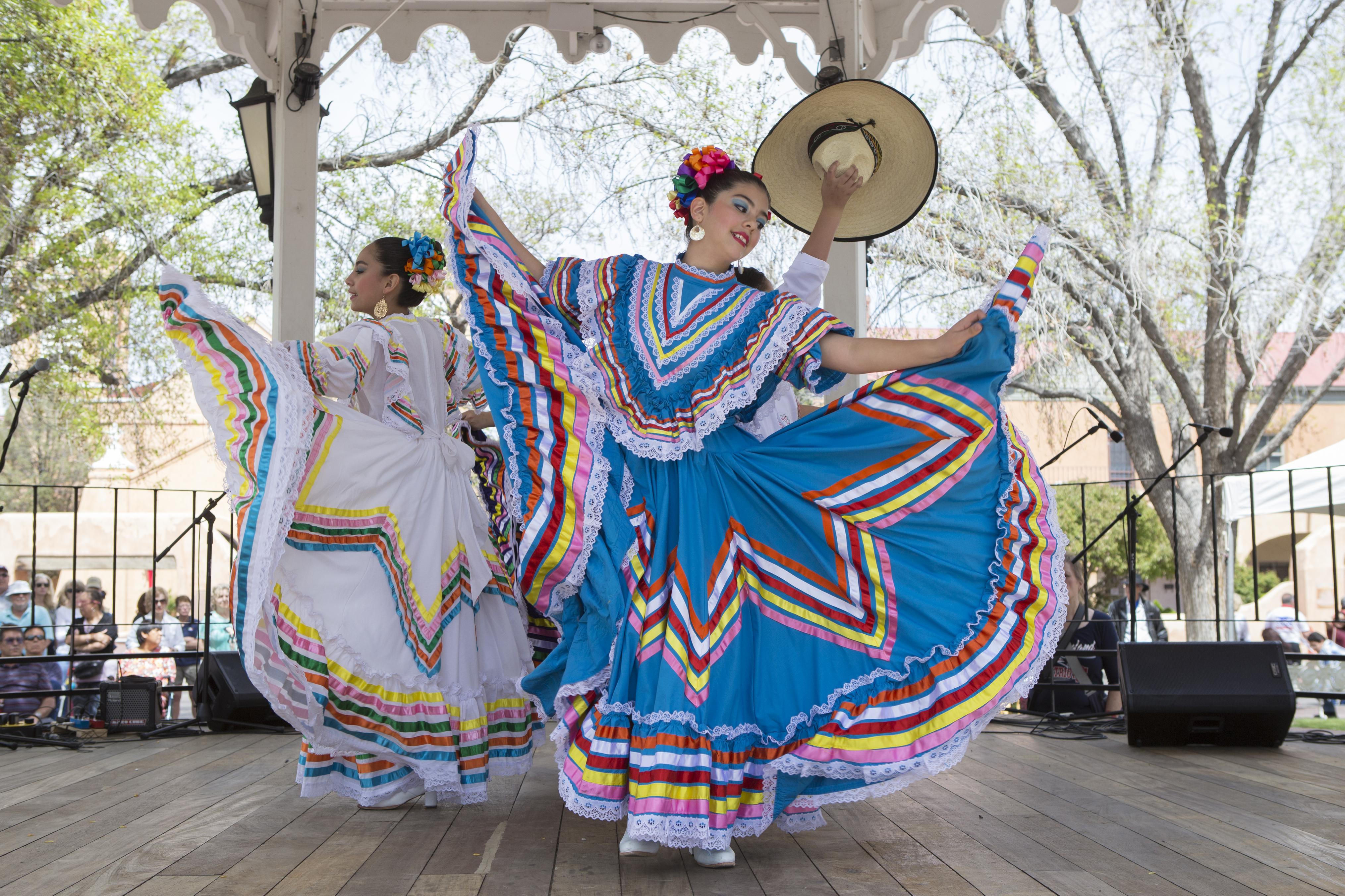 A PNG of dancers in the Old Town Gazebo wearing traditional colorful dresses.