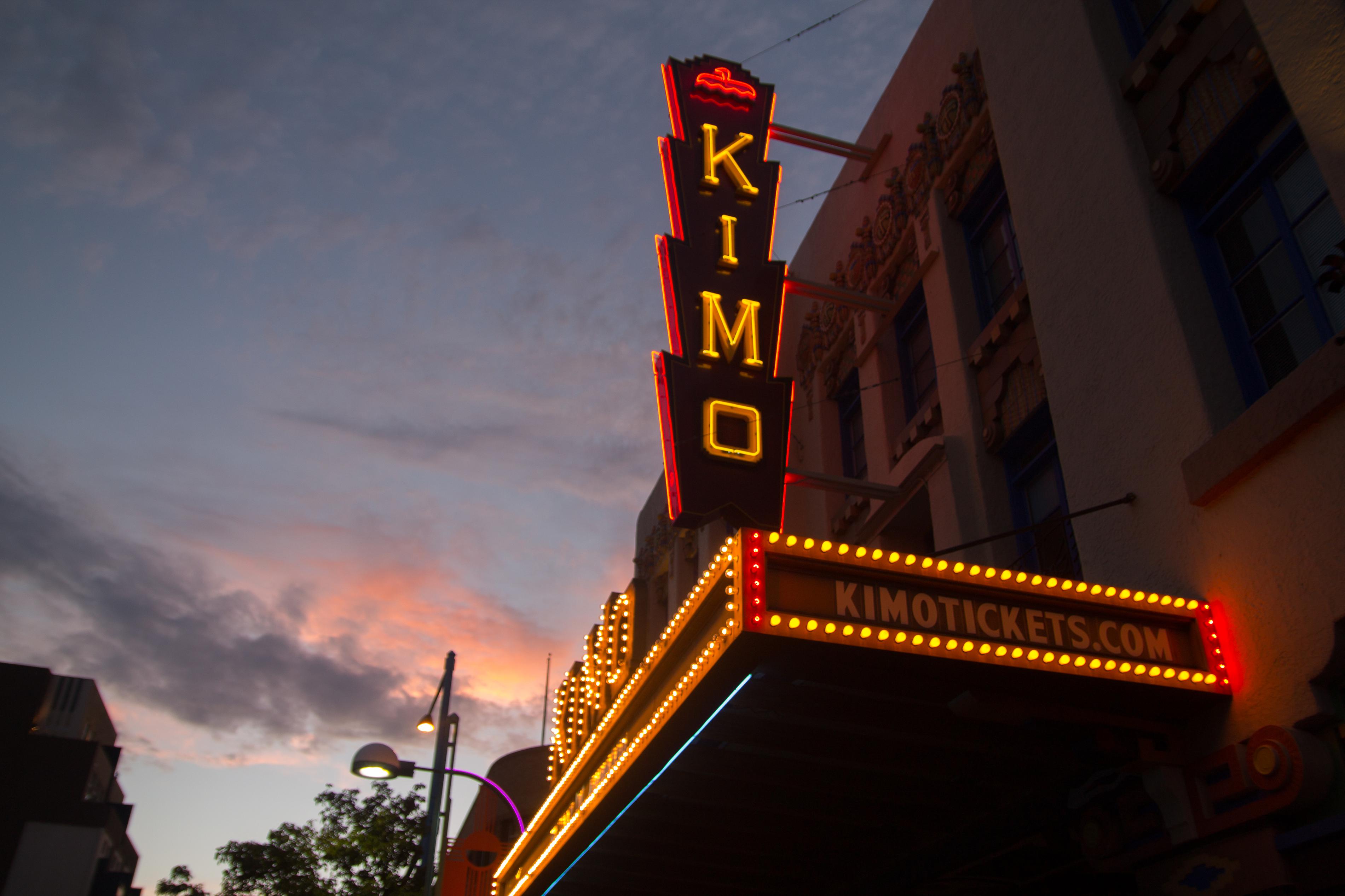 The neon sign of the KiMo Theatre at dusk.