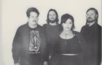 Sweet Roll Black and white photo of four people standing side by side against a plain background, with two men on the left and right and a woman and man in the center.