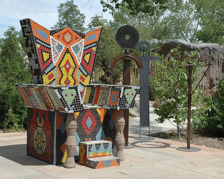 Large throne covered in brightly colored glass marbles and mosaic tiles.
