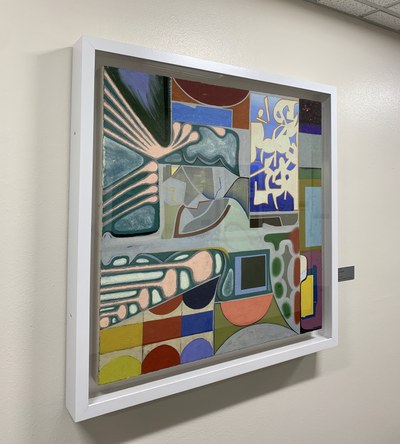 Multi-colored abstract painting framed with a white frame.