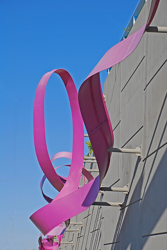A large "ribbon" of purple steel winding along a wall at the airport.