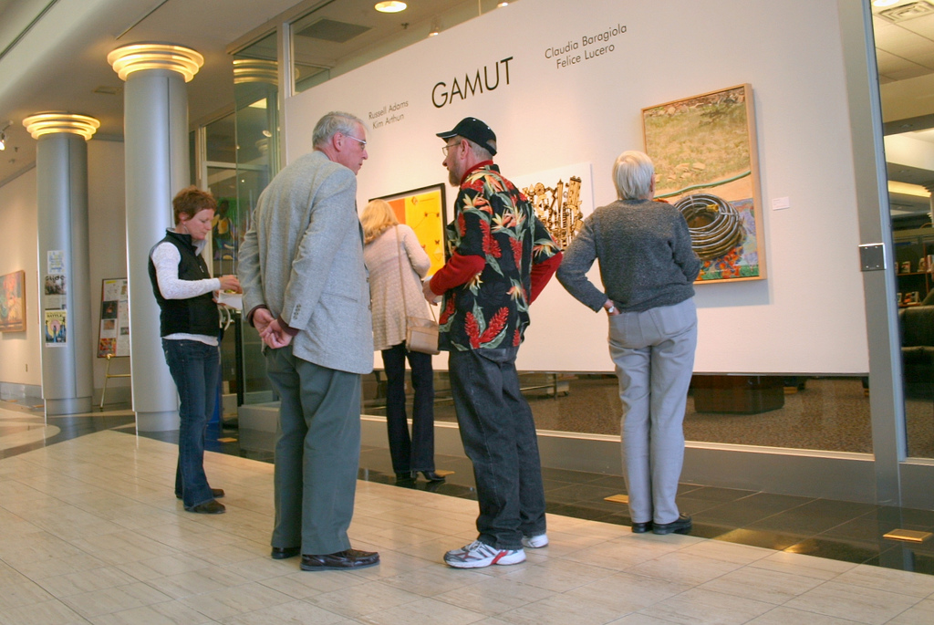 A group of patrons explore an art exhibit in the South Broadway Cultural Center.