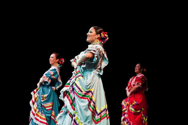 Three flamenco dancers performing on a stage.