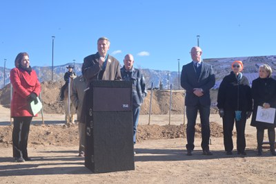 Mayor Tim Keller speaking and surrounded by City Councilor Brook Bassan and State leaders.