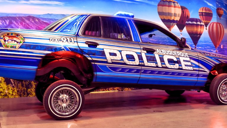 A police vehicle with custom paint, wheels, and hydraulics.