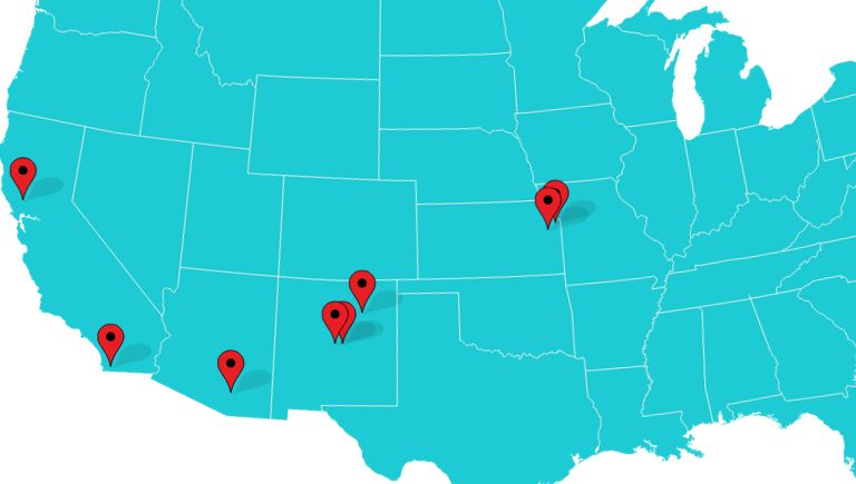 A turquoise US map with red pins.