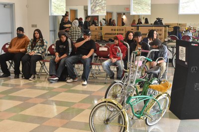 Lowrider bikes in the foreground with students sitting in the background at the launch of the Duke City Leadership Lowrider Bike Club on March 1, 2023.