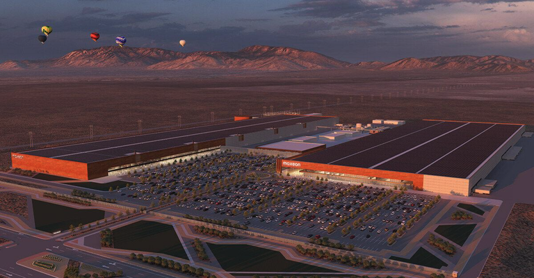 An image of the 1.9 million square foot Maxeon Solar Technologies manufacturing facility with the Sandia Mountains in the background and several hot air balloons in the sky.