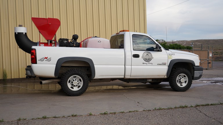 A white City of Albuquerque pickup truck with a buffalo turbine affixed to its truck bed for dispersing mosquito spray.