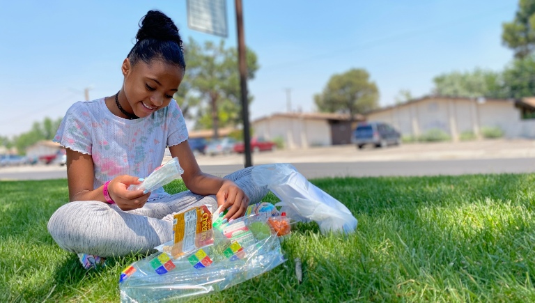 A girl eating lunch in a grassy park