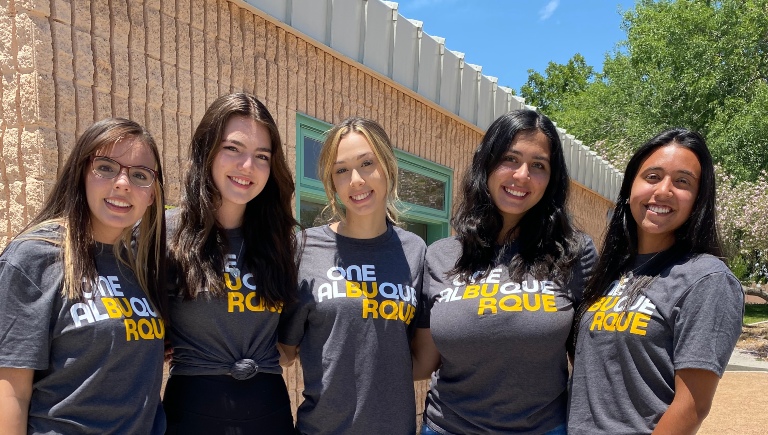 Five Family & Community Services Department employees wearing the same dark grey t-shirt