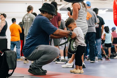 Image of man and child putting on boxing gloves