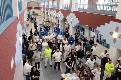 A room full of painters all looking the same direction in a room they painted red and white.
