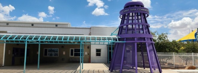 A purple tower that says Johny Tapia Community Center outside of a building.