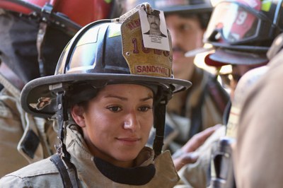 2026 911 Memorial Stair Climb Fire Fighter Sandoval A female AFR firefighter named Sandoval wearing full gear with a photo of a fallen firefighter on her helmet.