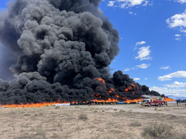 Atkore Fire 2023 A firetruck and firefighters in front of a large fire at a dump.
