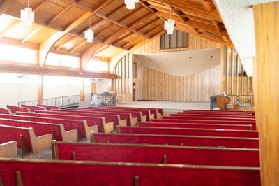 The view from the side row of red benches looking at a stage.
