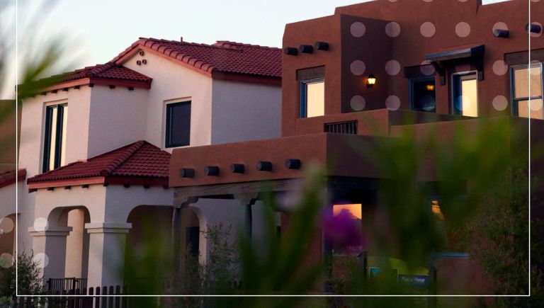 A close up of two stucco houses.`