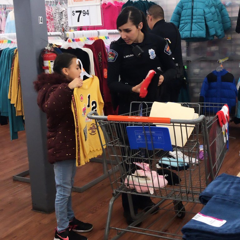 An APD Officer shopping for clothes with a young girl 