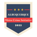 The 2022 Metro Crime Initiative (MCI) logo, featuring dark blue badge shape, a red rectangle, and the text Albuquerque Metro Crime Initiative 2022.