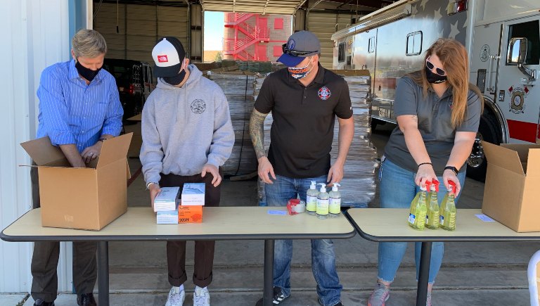 Mayor Keller and three staff members packing cleaning supplies into boxes.