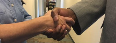 A photo of two people shaking hands.