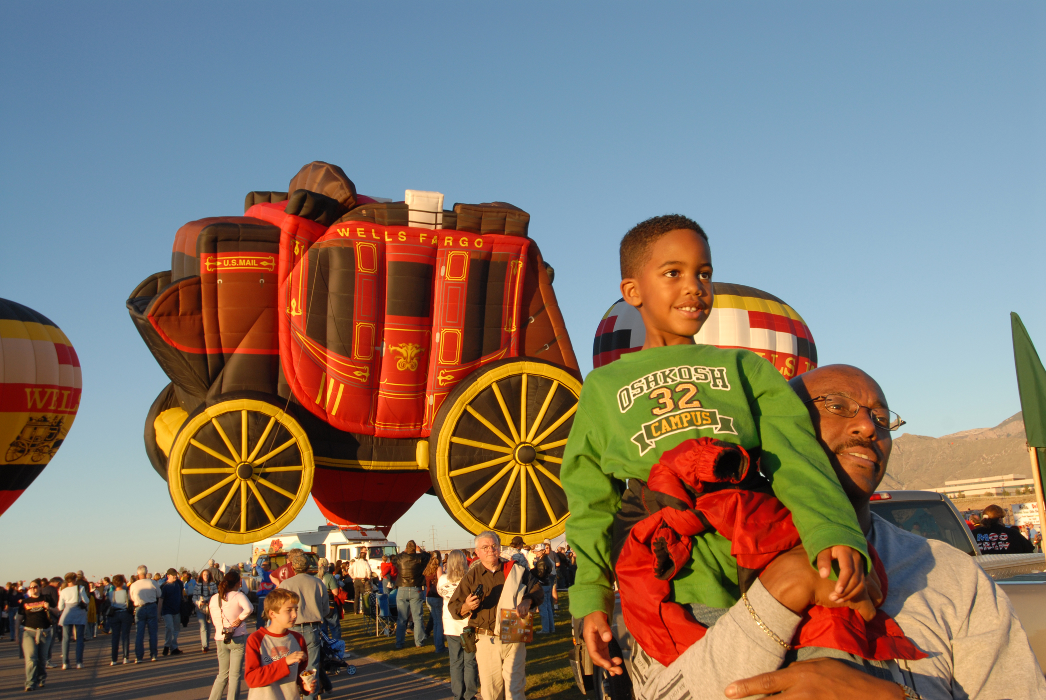 An African American father holding up his young son during Albuquerque International Balloon Fiesta