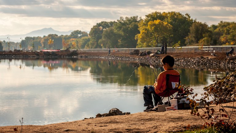 A boy fishing at Tingley Beach at sunrise.